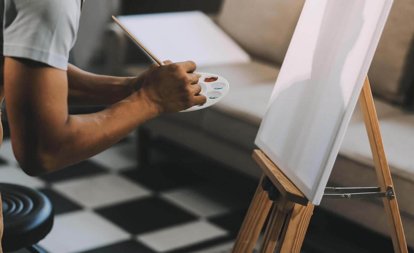 Young male artist painting picture in studio photo