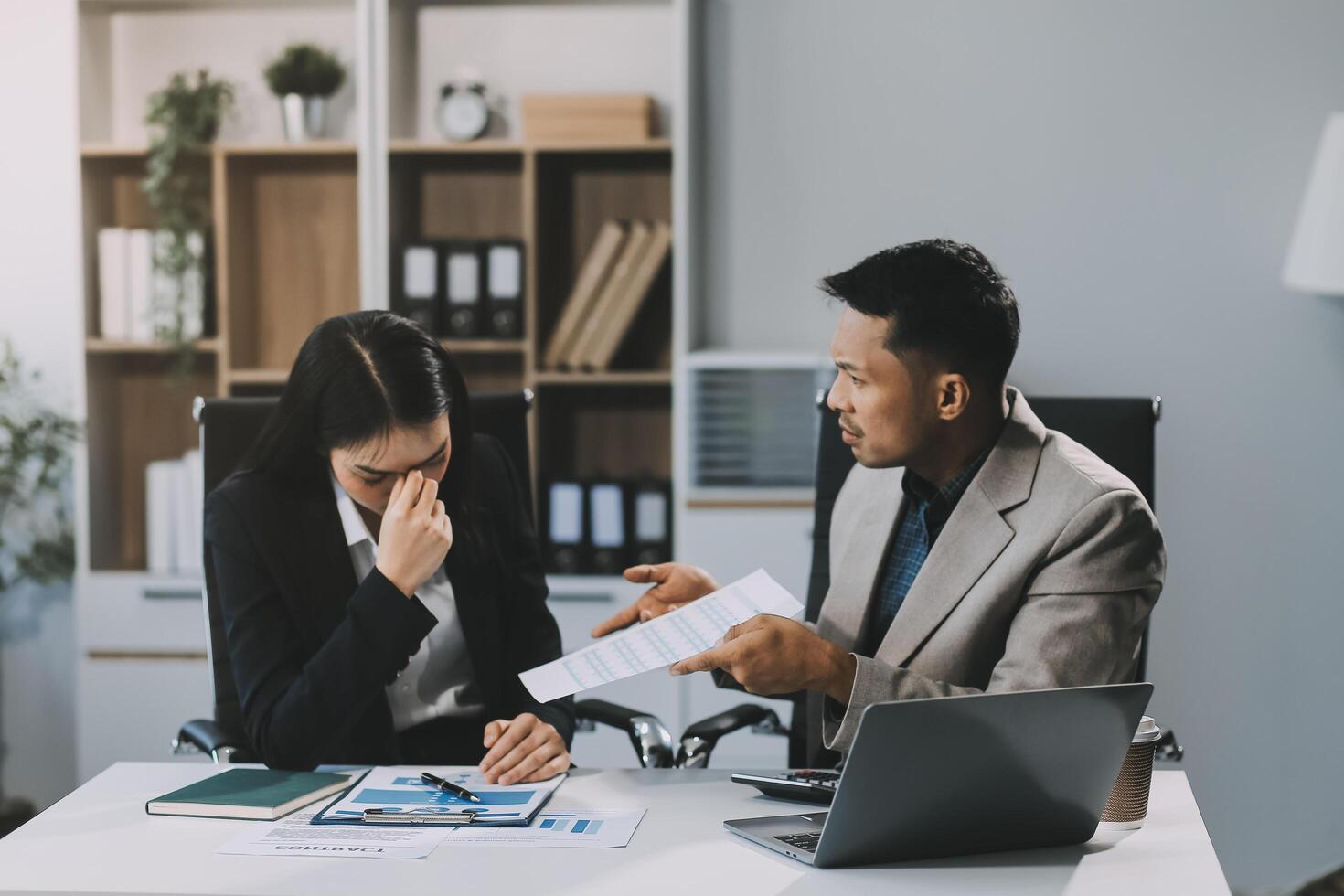 Manager is hard talking with employee in an office. Businessmen arguing at workplace, disagreeing over document, partners having conflict while negotiating, business deal failure photo