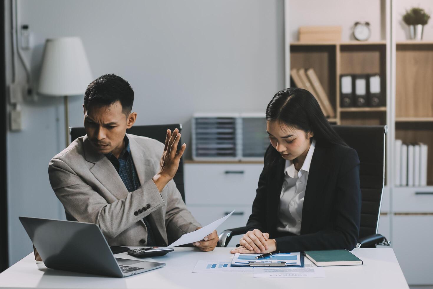 Manager is hard talking with employee in an office. Businessmen arguing at workplace, disagreeing over document, partners having conflict while negotiating, business deal failure photo