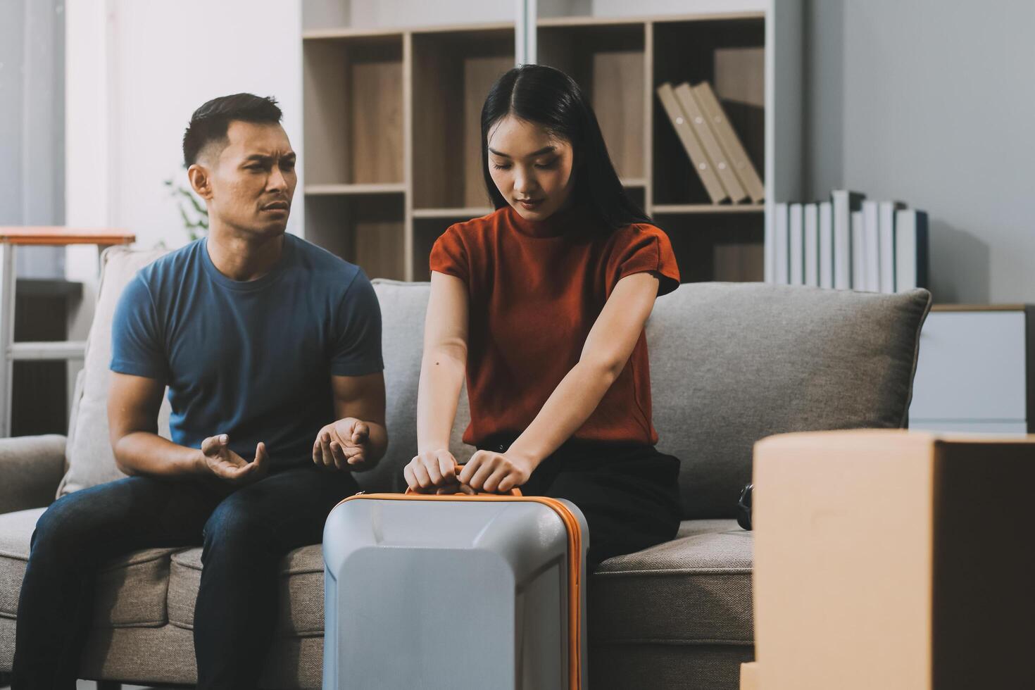 Family couple ignoring each other after a quarrel. Two people turn away and don't talk to each other. Angry young man and woman sitting back to back, with arms crossed on the sofa in the living room photo