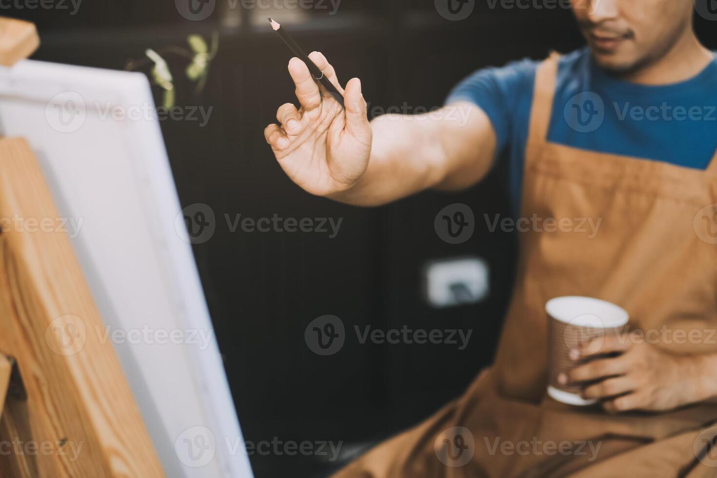 Young male artist painting picture in studio photo