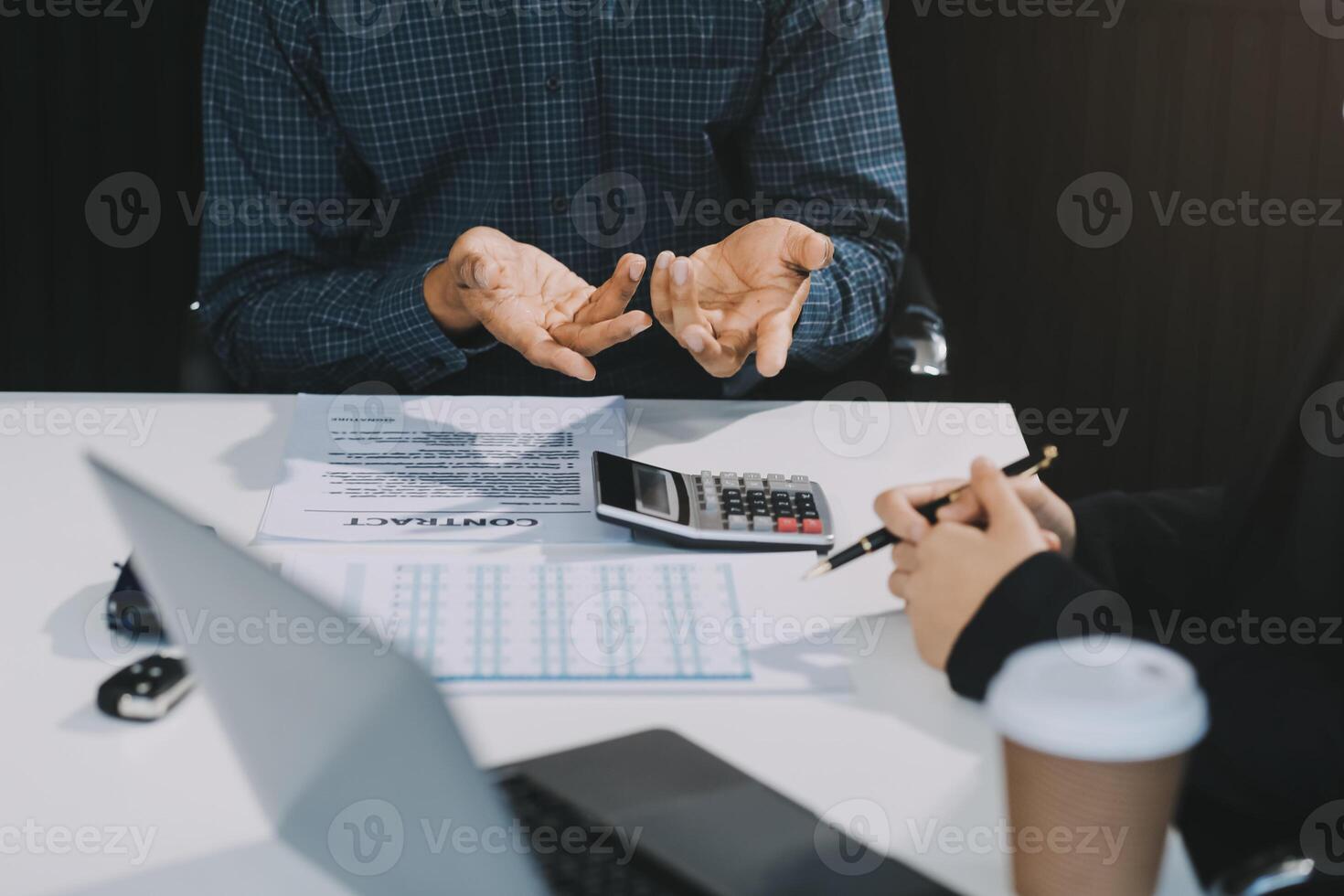 Car sales representative gives keys to new car owner, concept for car rental Focus on the key. Pick up the key. Close-up of the key transfer from the new machine to the buyer. photo