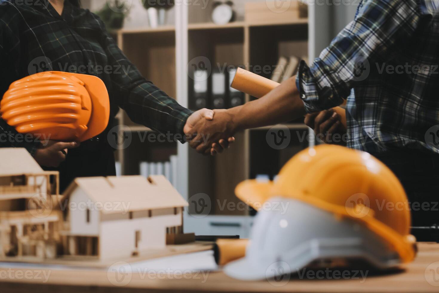 Architect and construction engineer holding hands while working for teamwork and cooperation concept after completing an agreement at construction site, office, close-up image photo