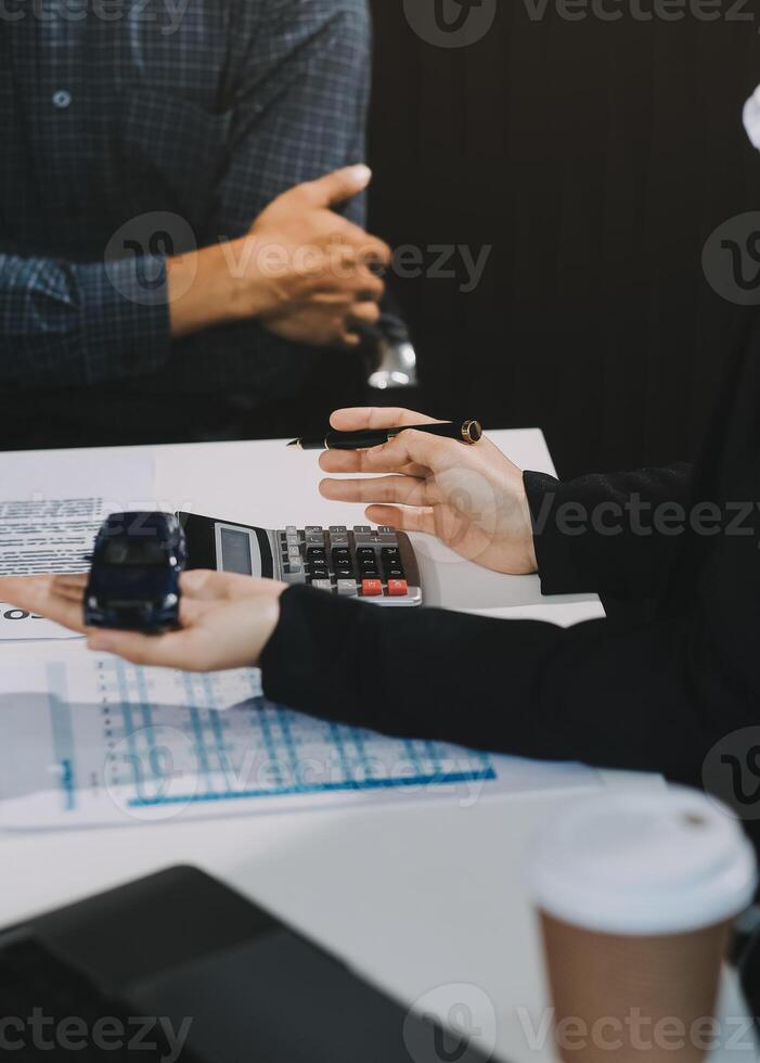 Car sales representative gives keys to new car owner, concept for car rental Focus on the key. Pick up the key. Close-up of the key transfer from the new machine to the buyer. photo