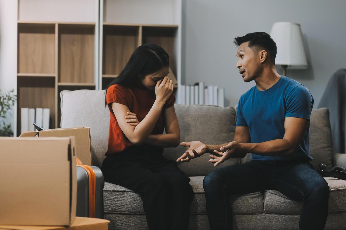 Family couple ignoring each other after a quarrel. Two people turn away and don't talk to each other. Angry young man and woman sitting back to back, with arms crossed on the sofa in the living room photo