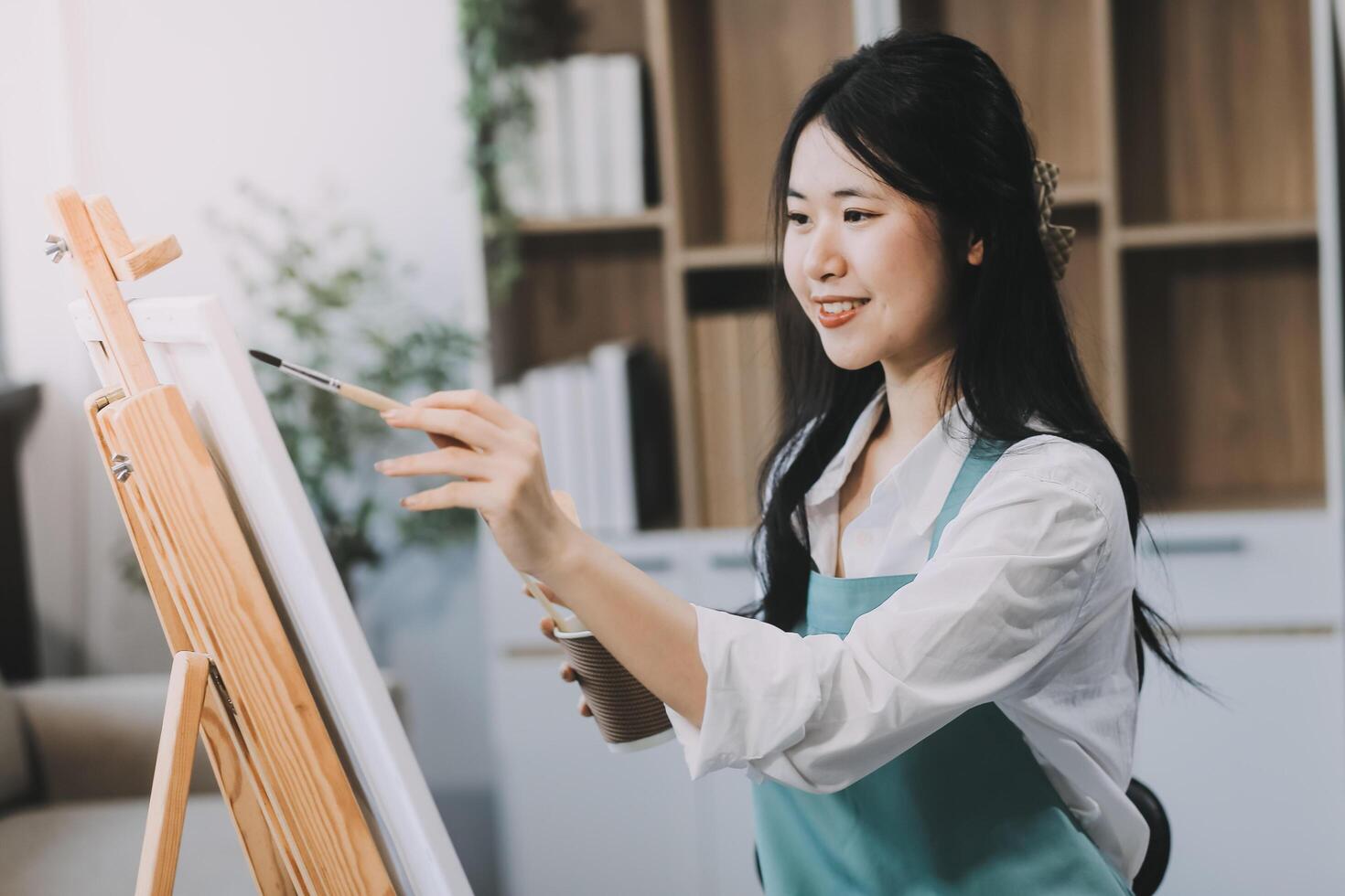 Pretty talented female painter painting on easel, making colorful sketches, creating marine landscape. Beautiful female artist painting with watercolor paints. Creativity and imagination concept photo