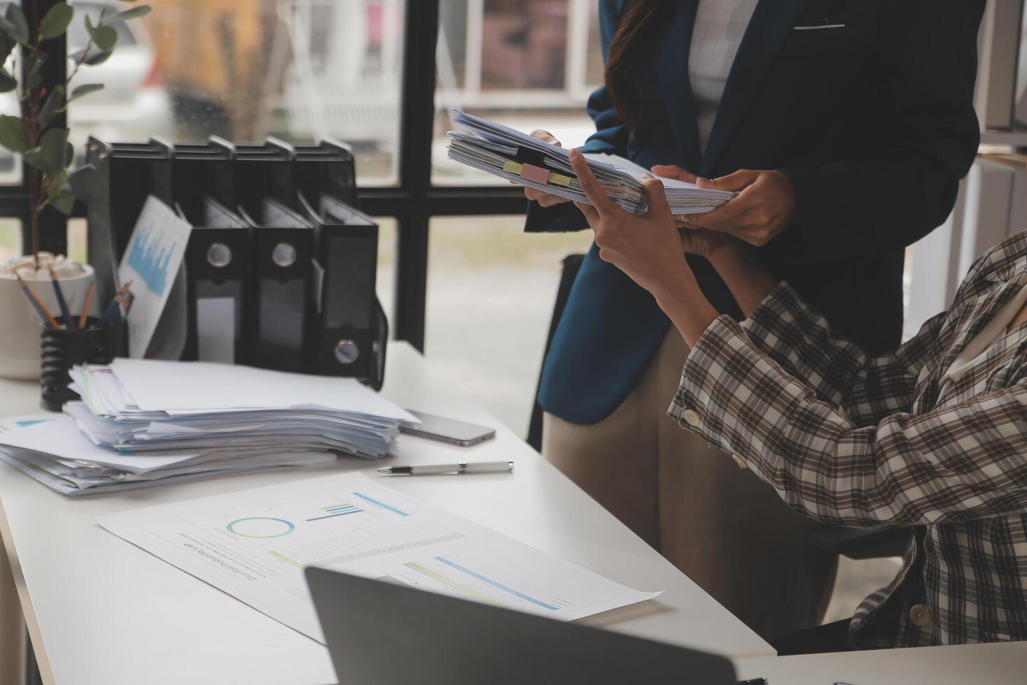 Group of confident business people point to graphs and charts to analyze market data, balance sheet, account, net profit to plan new sales strategies to increase production capacity. photo
