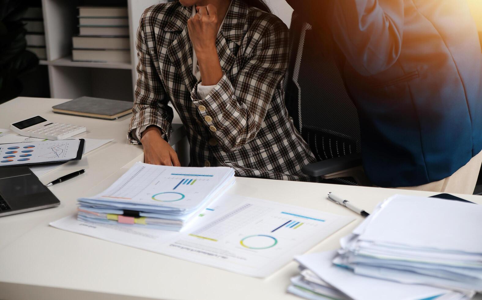 Group of confident business people point to graphs and charts to analyze market data, balance sheet, account, net profit to plan new sales strategies to increase production capacity. photo