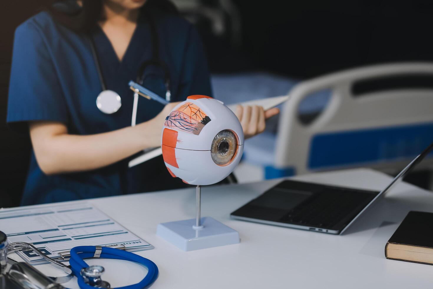 Ophthalmologist doctor in clinic, part of eye model on desk, oculus sample photo
