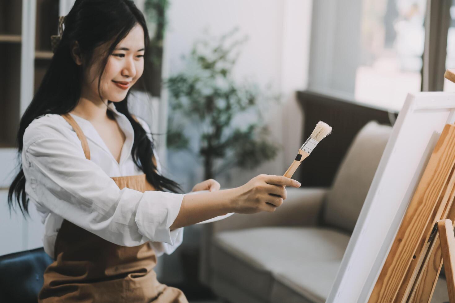 Pretty talented female painter painting on easel, making colorful sketches, creating marine landscape. Beautiful female artist painting with watercolor paints. Creativity and imagination concept photo