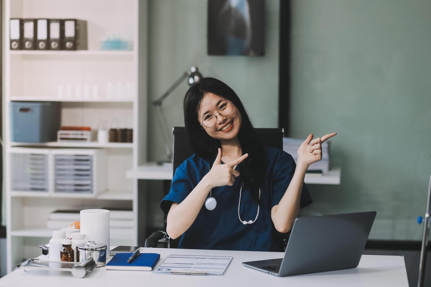 Portrait of beautiful physician doctor sit on table in office hospital. Attractive therapist female practitioner pharmacist smile and looking at camera after success work from treatment in hospital. photo