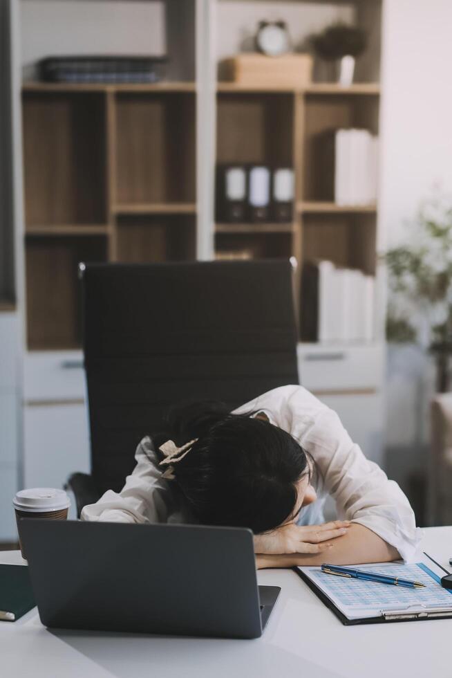 Asian women are stressed while working on laptop, Tired asian businesswoman with headache at office, feeling sick at work, copy space photo