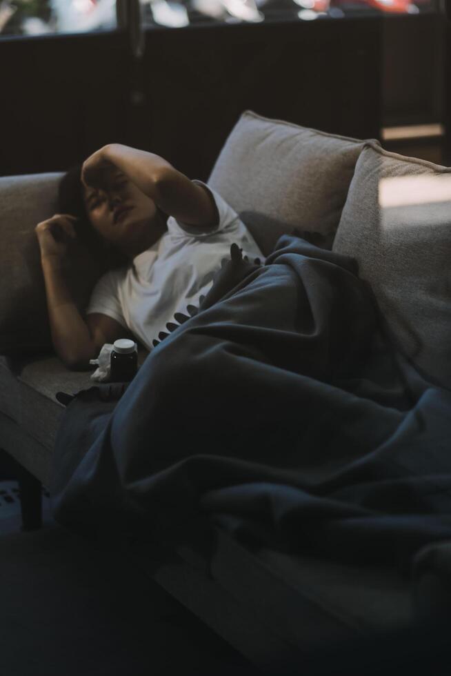 Cold medicine and sick woman drinking hot beverage to get well from flu, fever and virus. Dirty paper towels and tissues on table. Ill person wearing warm woolen stocking socks in winter. photo