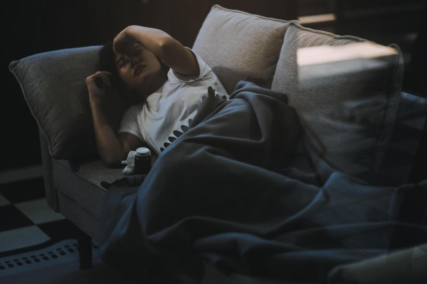 Cold medicine and sick woman drinking hot beverage to get well from flu, fever and virus. Dirty paper towels and tissues on table. Ill person wearing warm woolen stocking socks in winter. photo