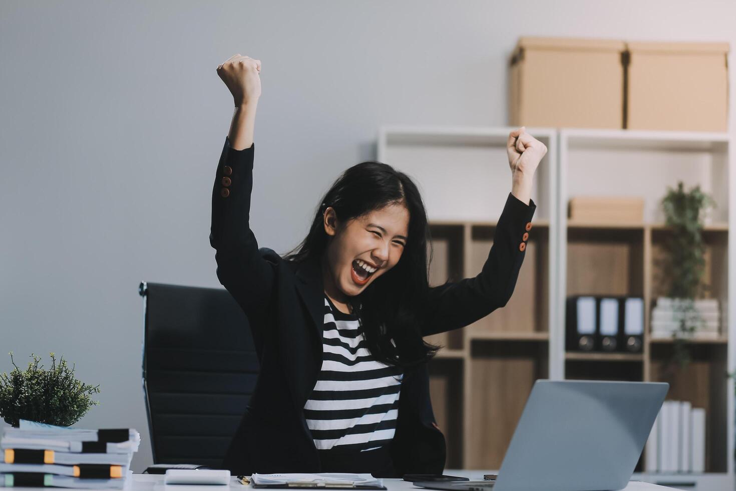 Asian business woman are delighted and happy with the work they do on their tablet, laptop and taking notes at office. photo
