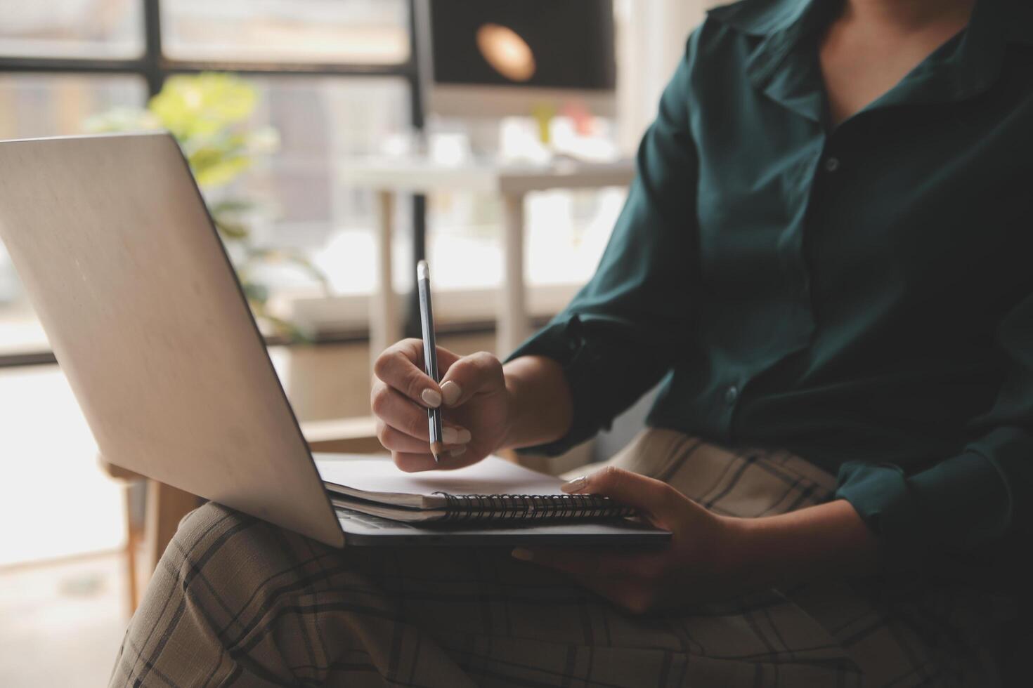 Distracted from work worried young woman sitting on couch with laptop, thinking of problems. Pensive unmotivated lady looking at window, feeling lack of energy, doing remote freelance tasks at home. photo