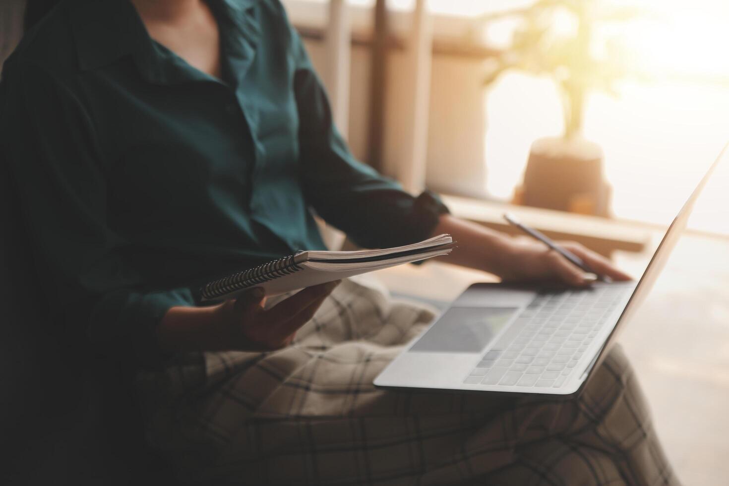 Distracted from work worried young woman sitting on couch with laptop, thinking of problems. Pensive unmotivated lady looking at window, feeling lack of energy, doing remote freelance tasks at home. photo