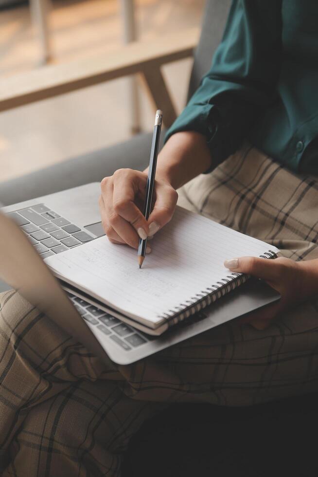 Distracted from work worried young woman sitting on couch with laptop, thinking of problems. Pensive unmotivated lady looking at window, feeling lack of energy, doing remote freelance tasks at home. photo