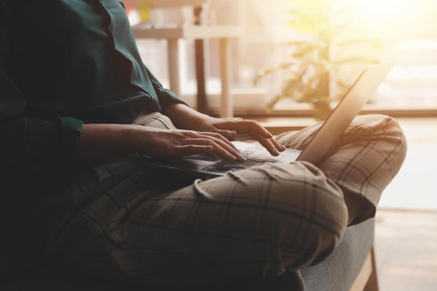 Distracted from work worried young woman sitting on couch with laptop, thinking of problems. Pensive unmotivated lady looking at window, feeling lack of energy, doing remote freelance tasks at home. photo