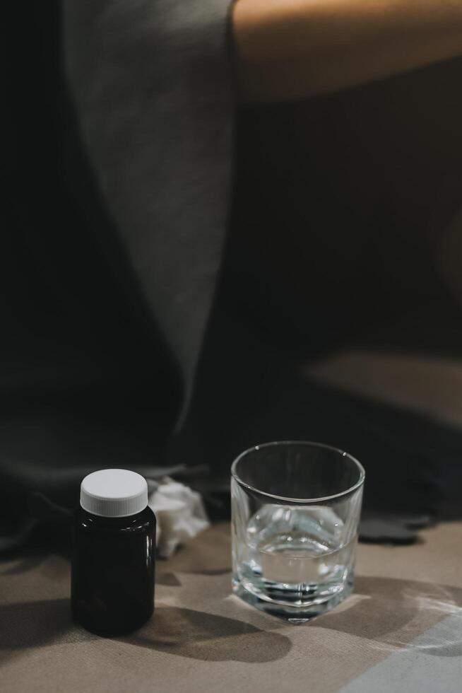 frío medicina y enfermo mujer Bebiendo caliente bebida a obtener bien desde gripe, fiebre y virus. sucio papel toallas y tejidos en mesa. enfermo persona vistiendo calentar de lana media calcetines en invierno. foto