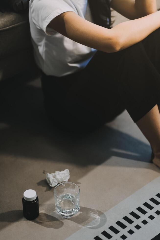Cold medicine and sick woman drinking hot beverage to get well from flu, fever and virus. Dirty paper towels and tissues on table. Ill person wearing warm woolen stocking socks in winter. photo