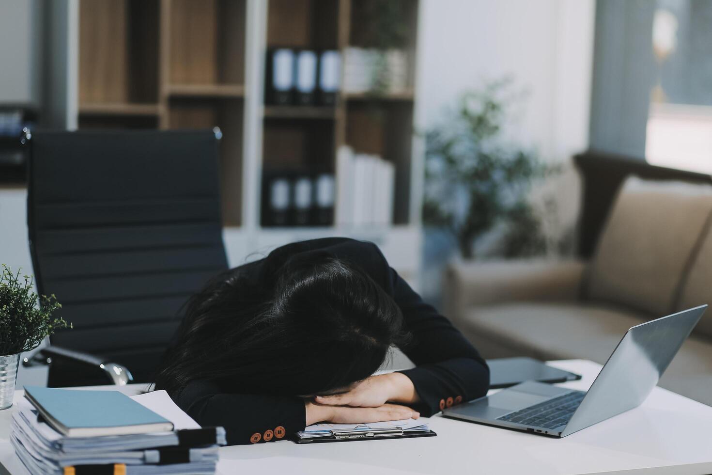Tired businesswoman sleeping on the desk, in front of the computer screen. photo