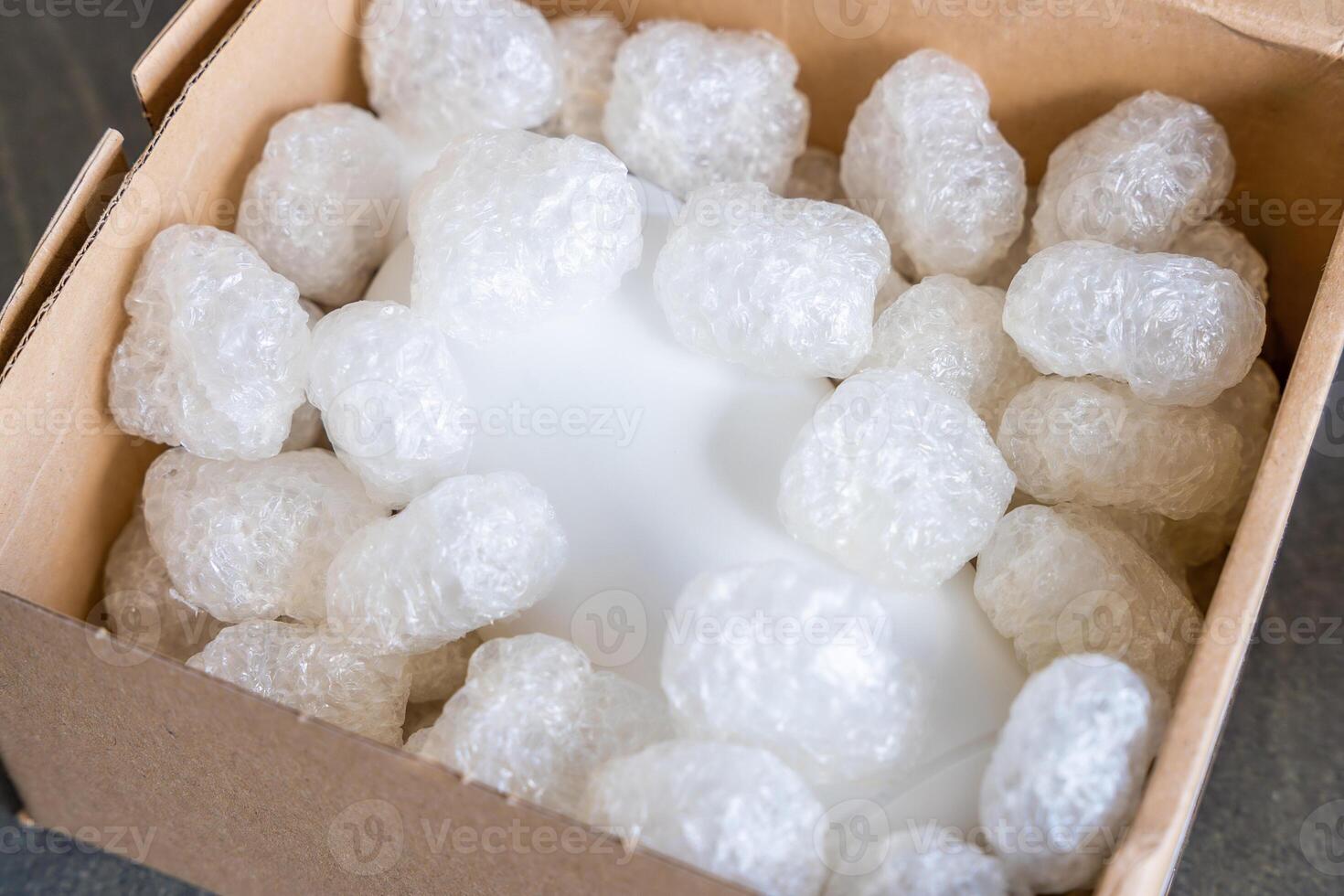 Eco packaging of parcels and white biodegradable filler. Box is filled with a filler safety for environment. Delivery of goods, parcels, delivery service, nature protection and recycling concept. photo