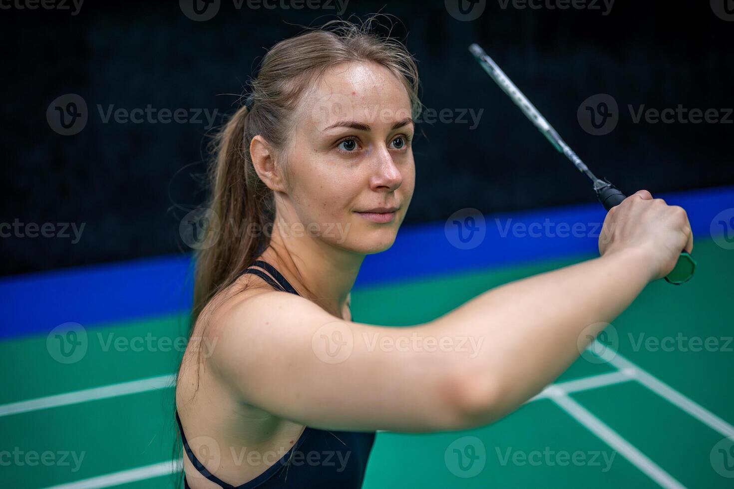 Sports young woman with racket and shuttlecock is posing before playing in badminton on inside court. High quality photo
