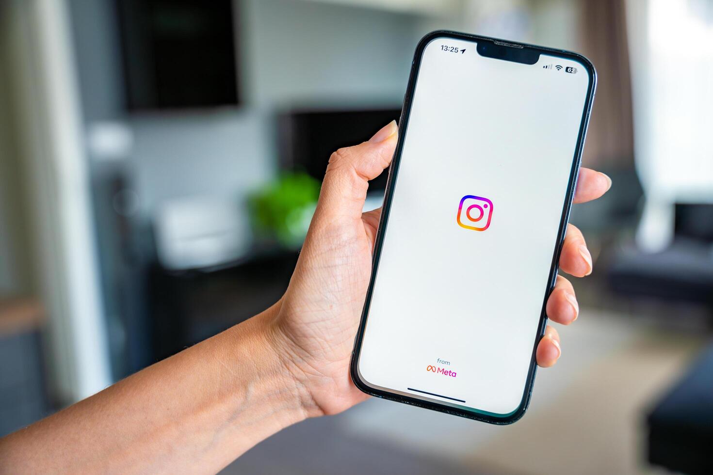 Prague, Czech republic - May 2, 2024. Woman holding iPhone with streaming photo and Instagram on the screen, using mobile application at home. High quality photo