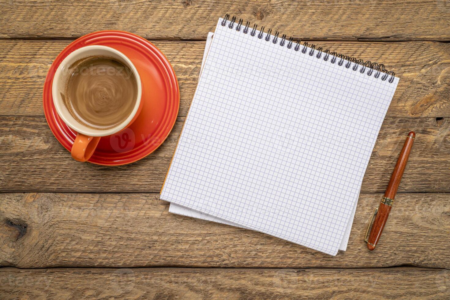 blank spiral notebook with grid paper, flat lay with coffee and pen on on weathered barn wood photo