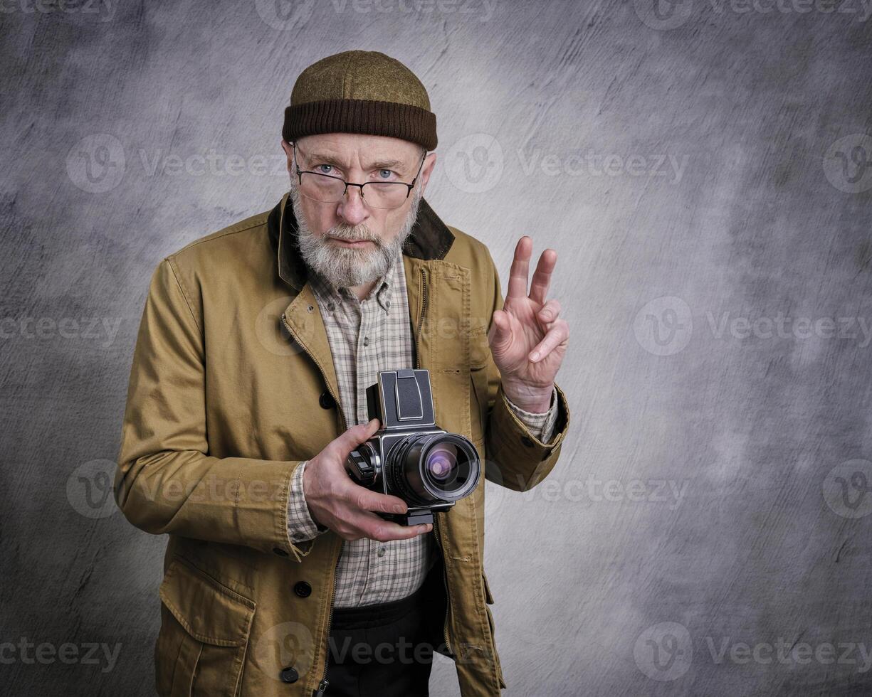 portrait of a senior male photographer with old camera photo