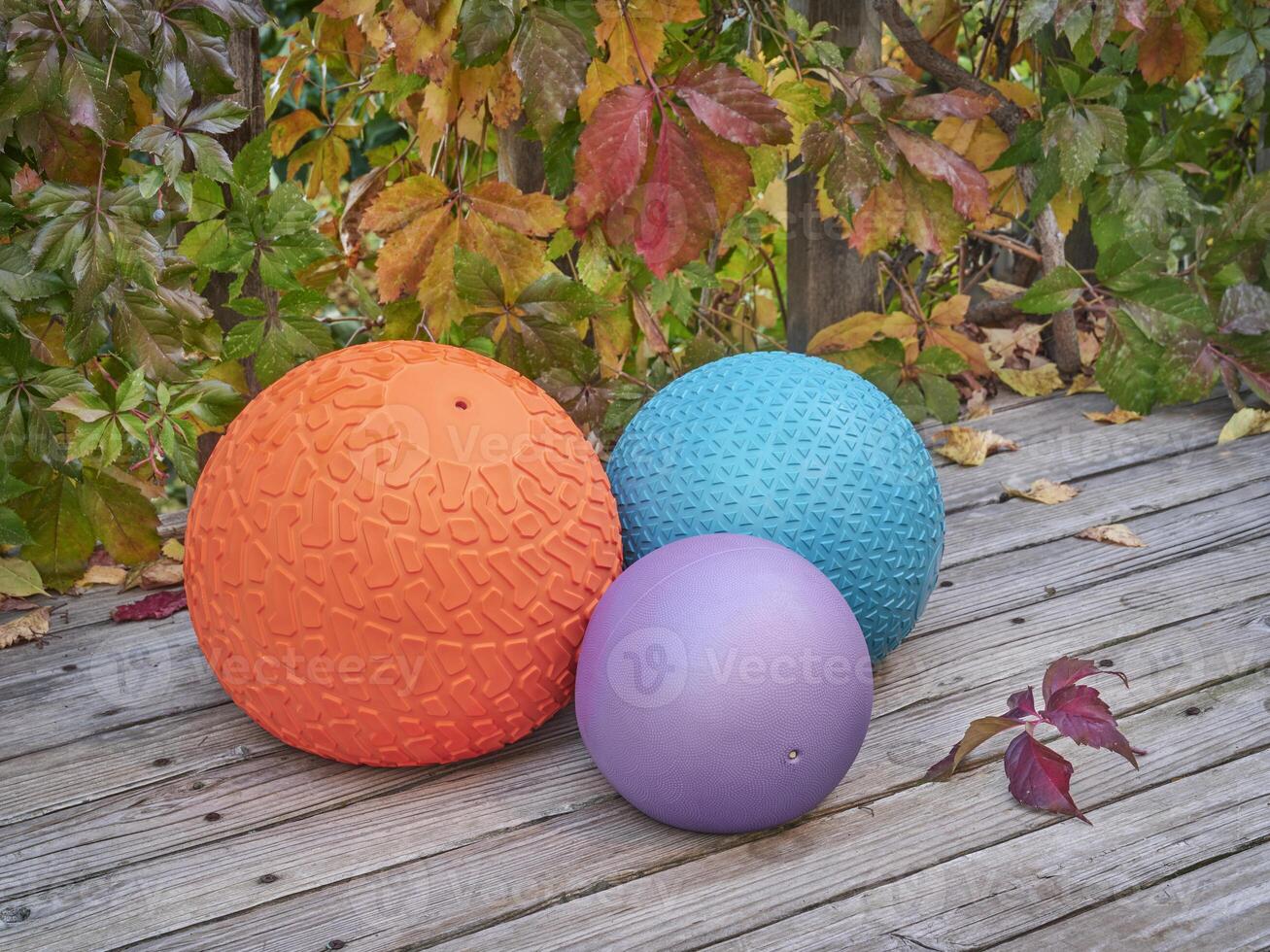 three slam balls on a backyard deck photo