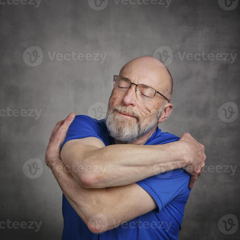 senior happy man is hugging himself photo