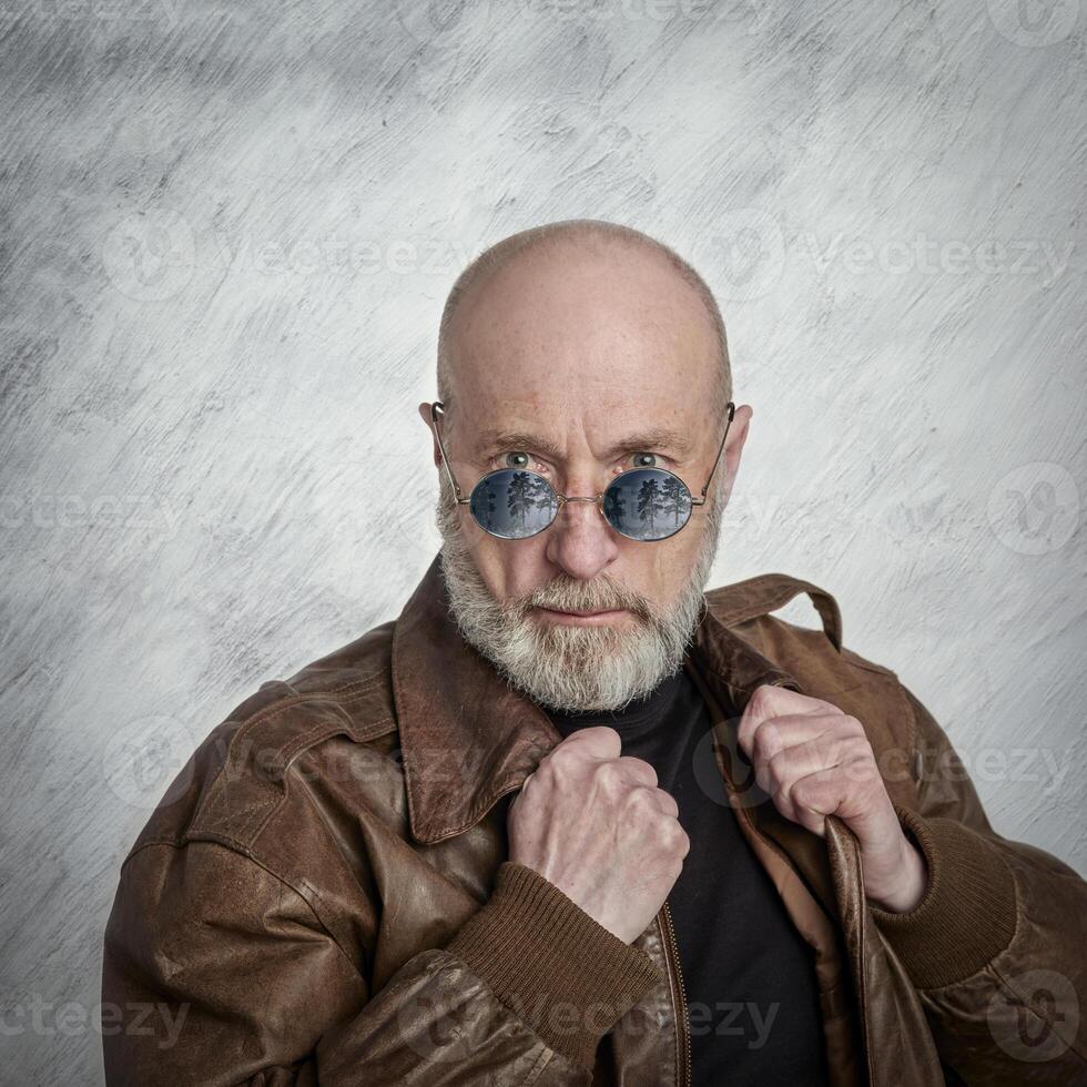 senior, handsome man with gray beard in leather jacket photo