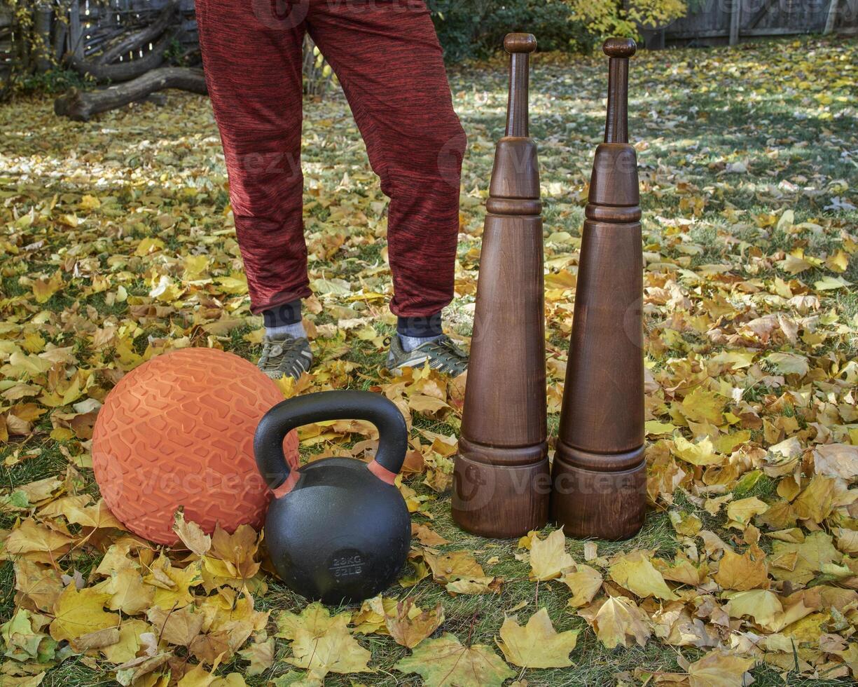 heavy iron kettlebell, slam ball and wooden Persian clubs photo