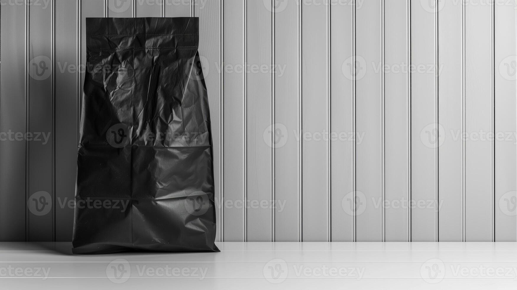 A black shopping bag is placed on a white wooden table in a room, mockup with copy space photo