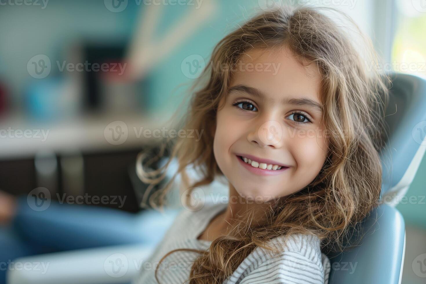 smiling girl at a dentist appointment sitting in a dental chair next to the doctor photo