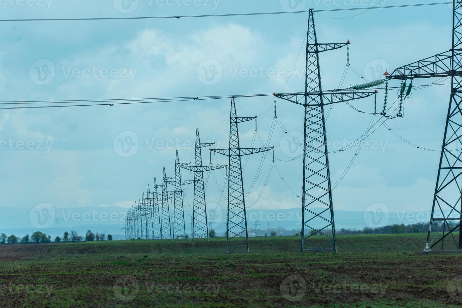 High voltage towers with sky background. Power line support with wires for electricity transmission. High voltage grid tower with wire cable at distribution station. Energy industry, energy saving photo