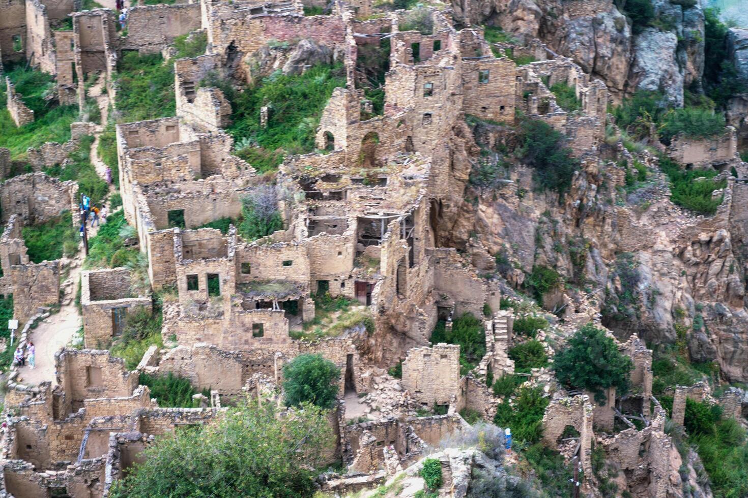 Dagestan Gamsutl. Ancient ghost town of Gamsutl old stone houses in abandoned Gamsutl mountain village in Dagestan, Abandoned etnic aul, summer landscape. photo