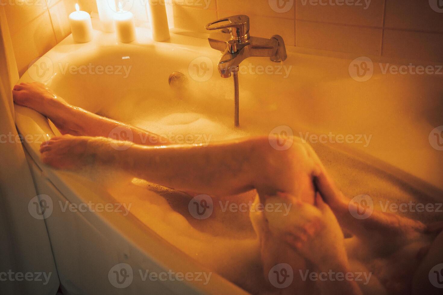 Women's feet in bath foam. View from above. Enjoy and relax in a spa hotel photo