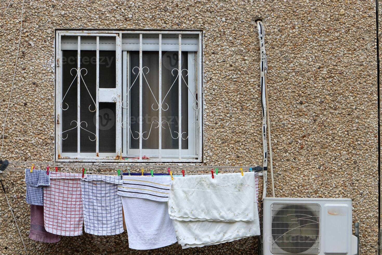 Washed laundry hangs on a rope outside the window. photo