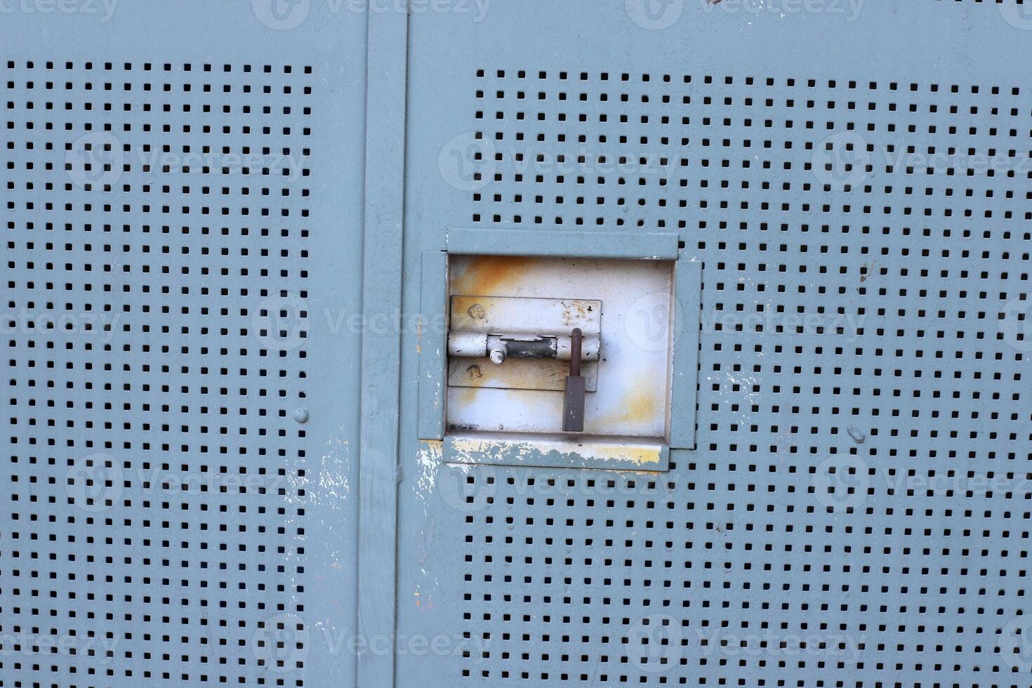 An old metal lock hangs on the fence. photo