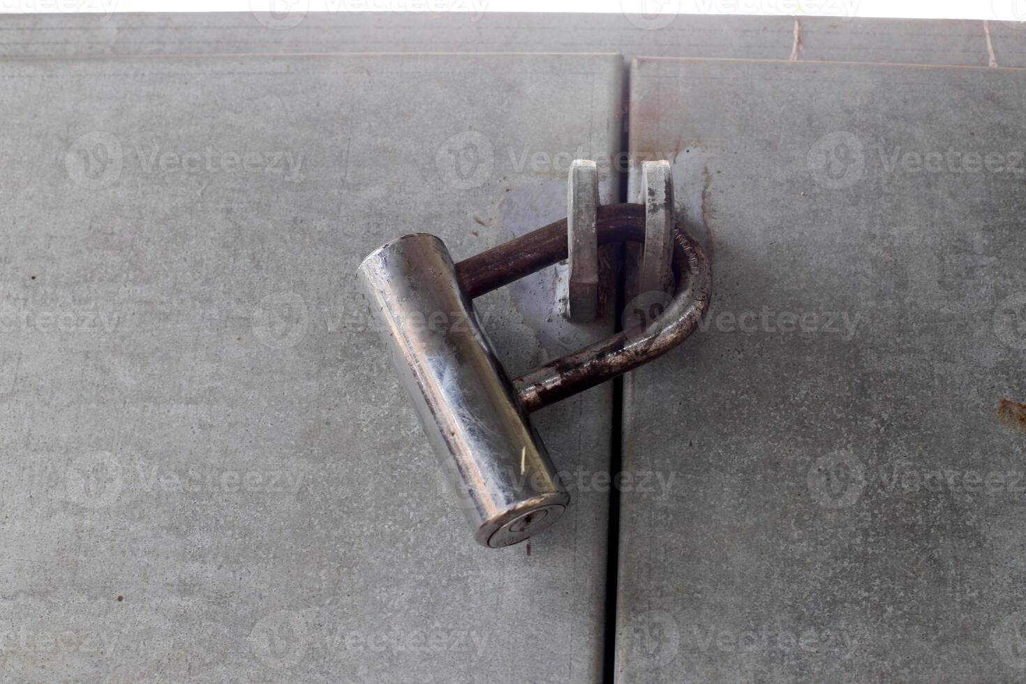 An old metal lock hangs on the fence. photo