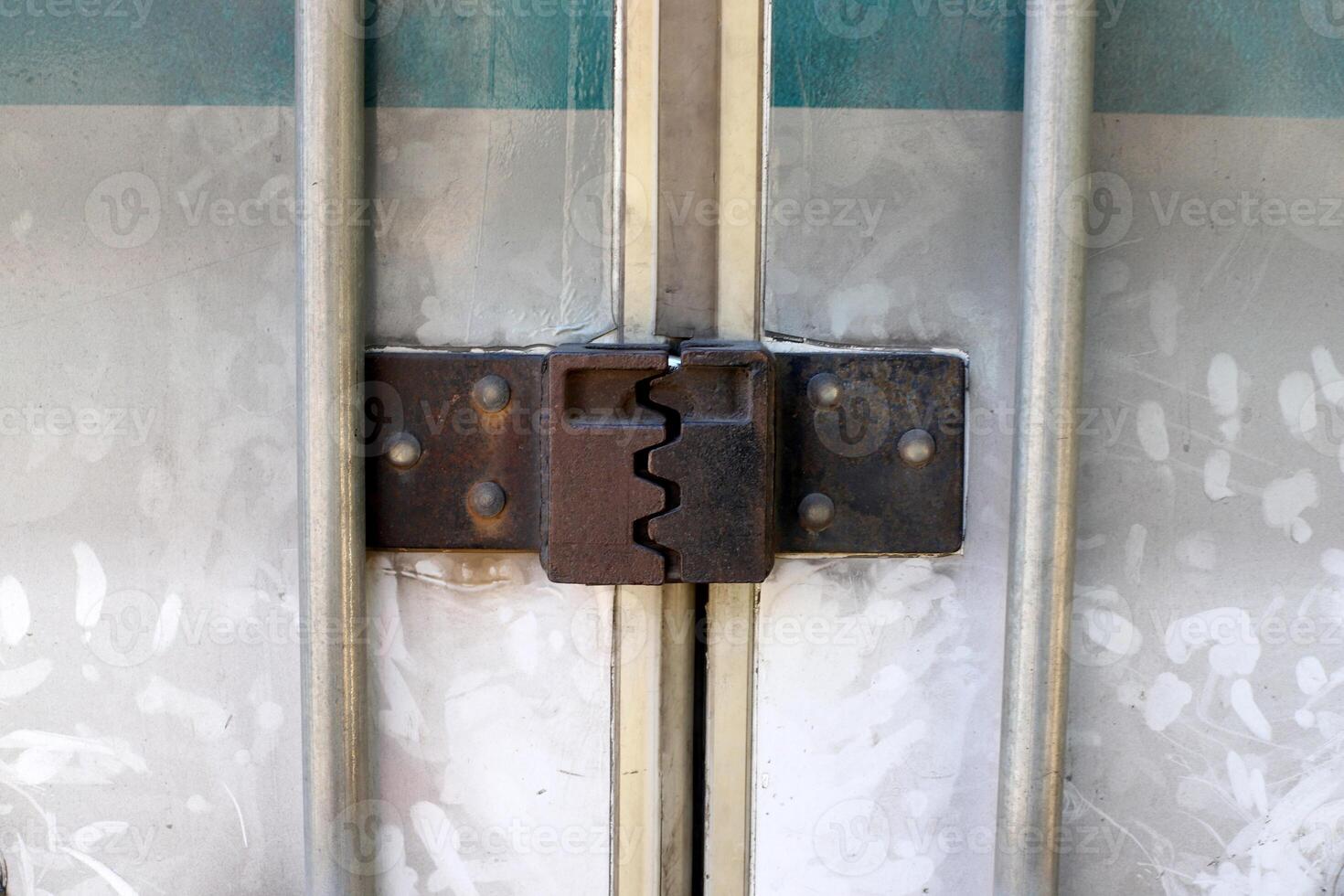 An old metal lock hangs on the fence. photo