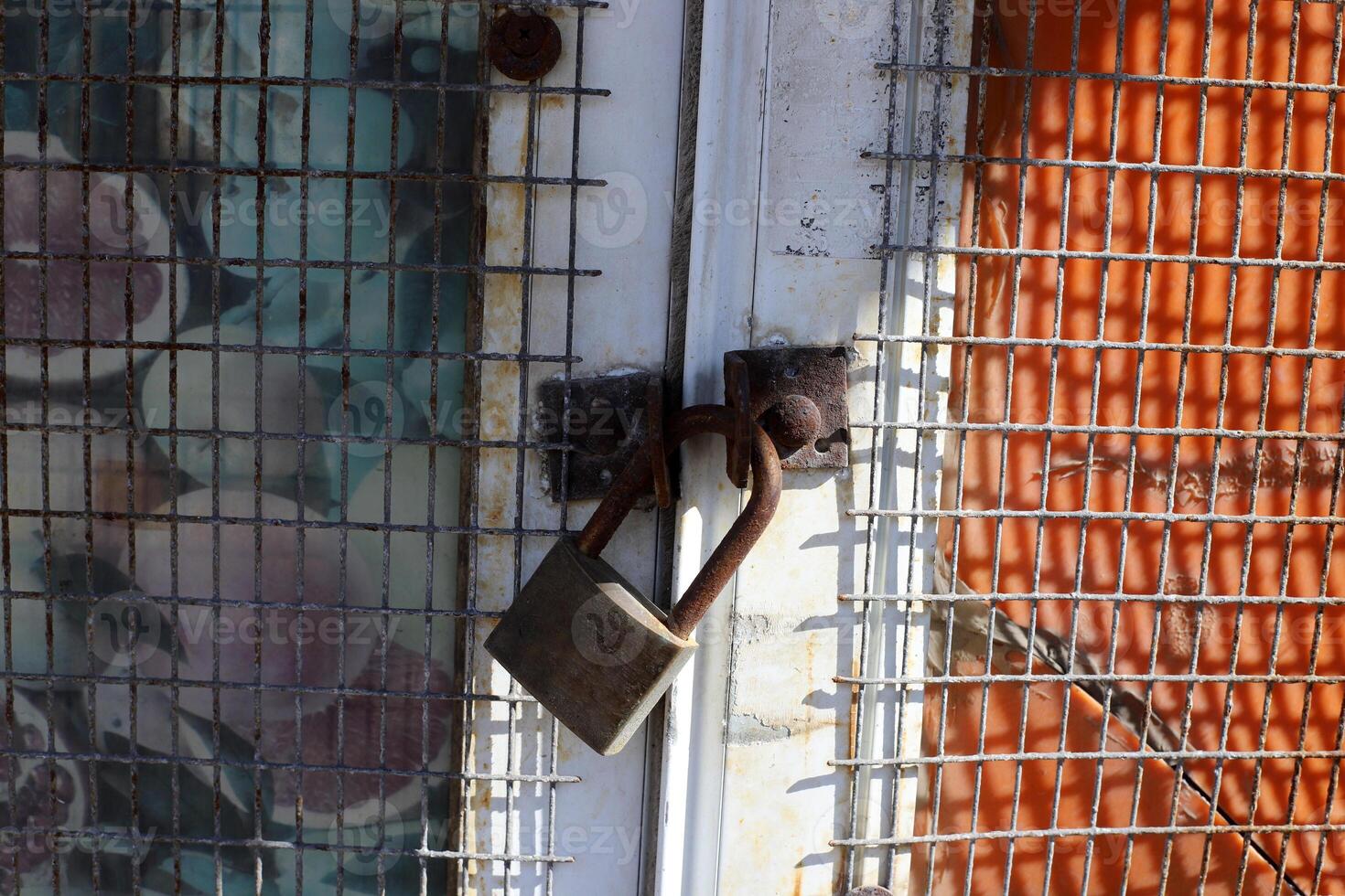 An old metal lock hangs on the fence. photo