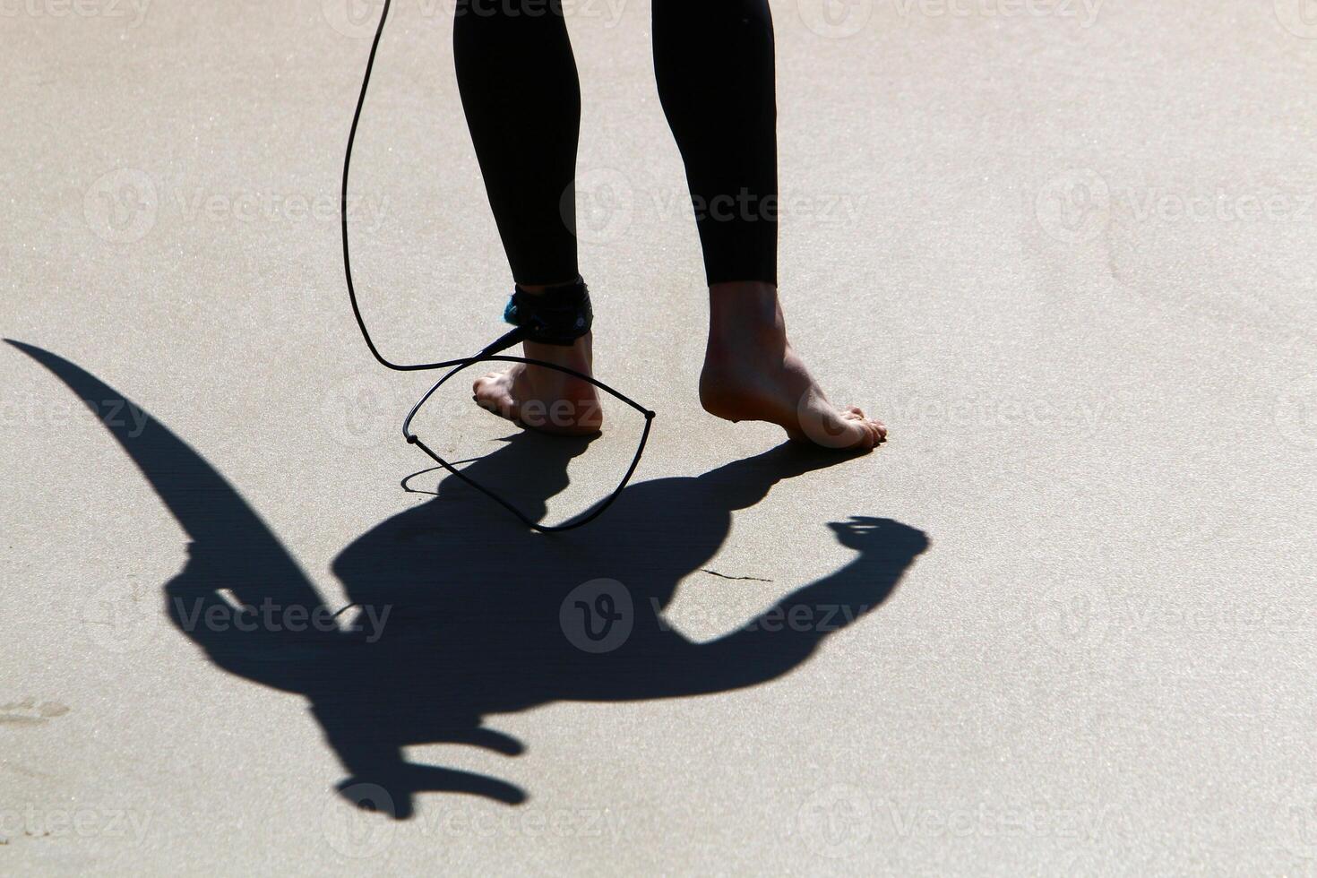 An athlete walks barefoot on the sand on the seashore. photo