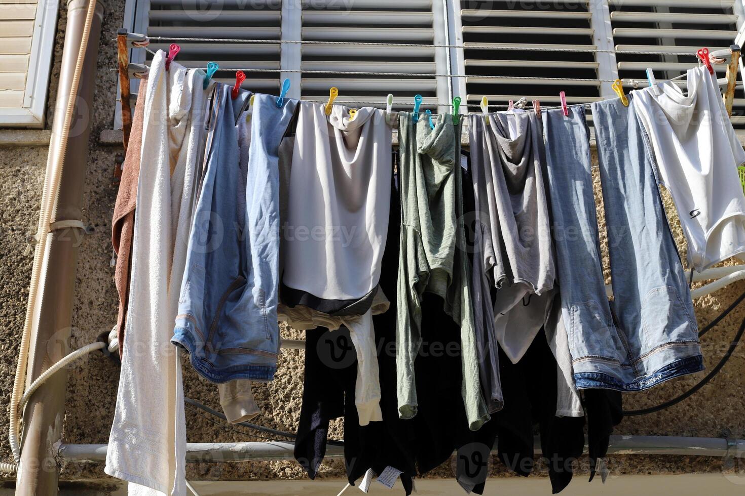 Washed laundry hangs on a rope outside the window. photo