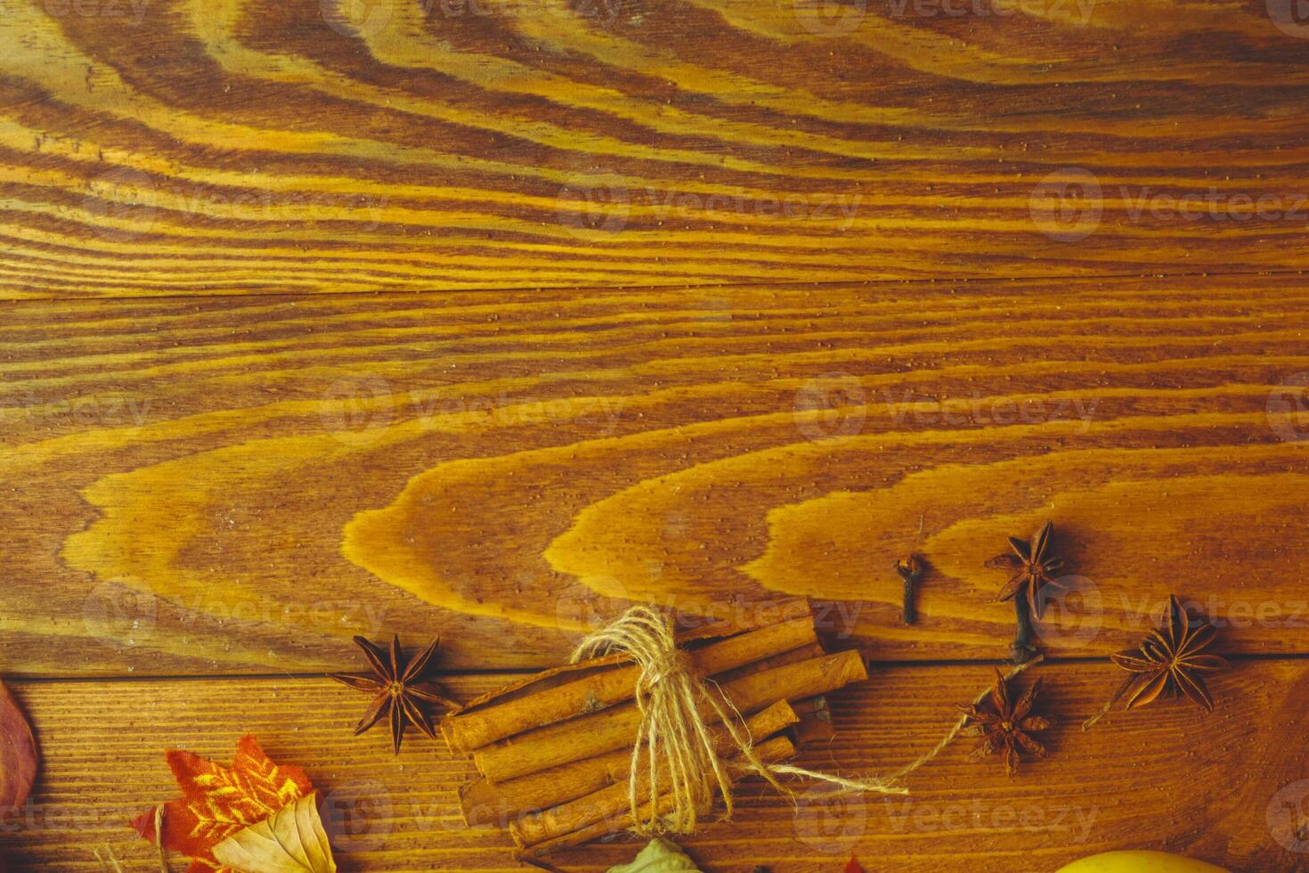 Wooden table. Autumn background with dry leaves, acorns cinnamon spices on wooden table. Copy space. Autumn background with dry leaves, cinnamon spices on photo