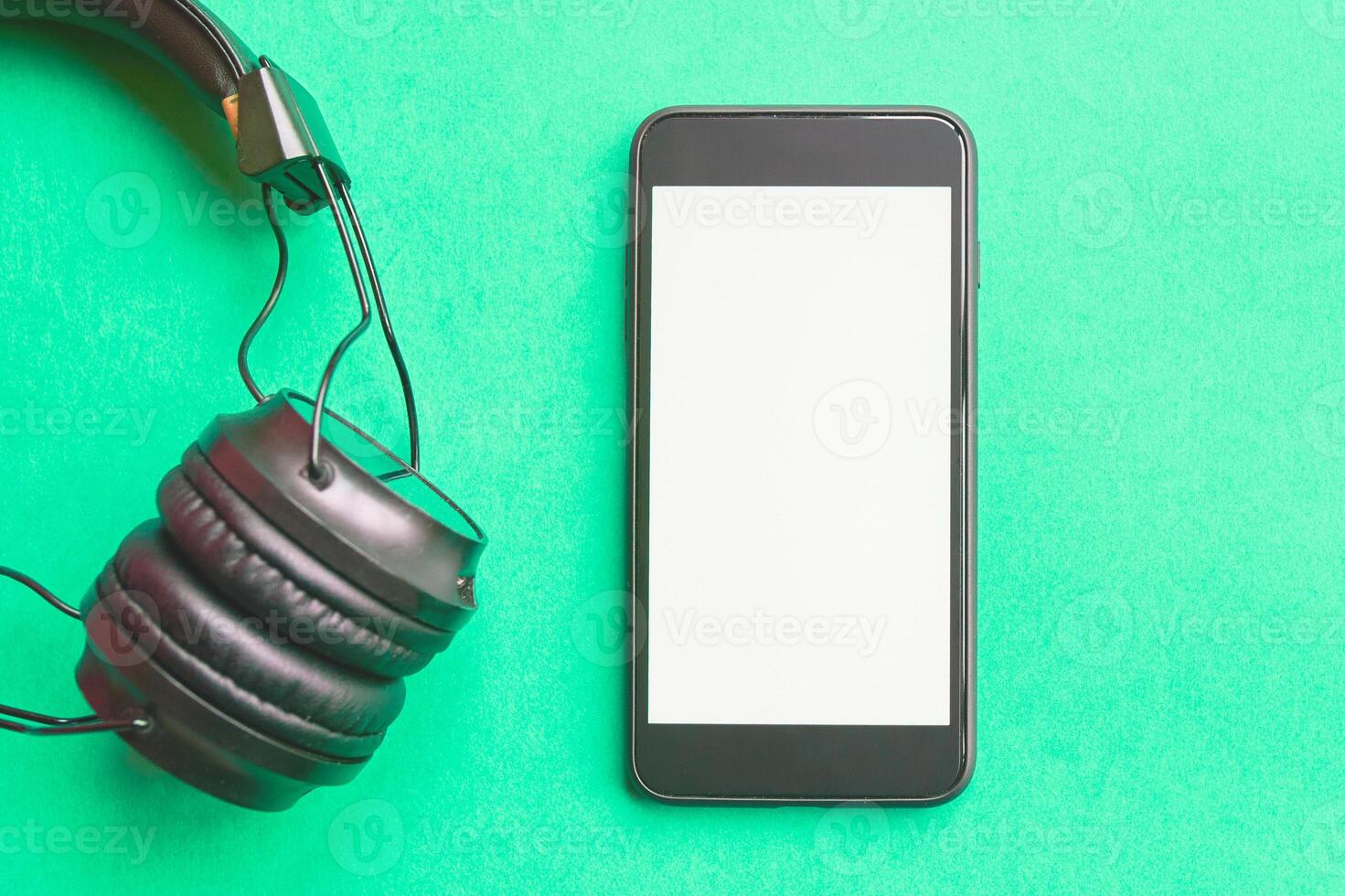 Headphones and smartphone on colorful background. Flat lay concept. headphones and telephone on green pastel backgrounds. photo