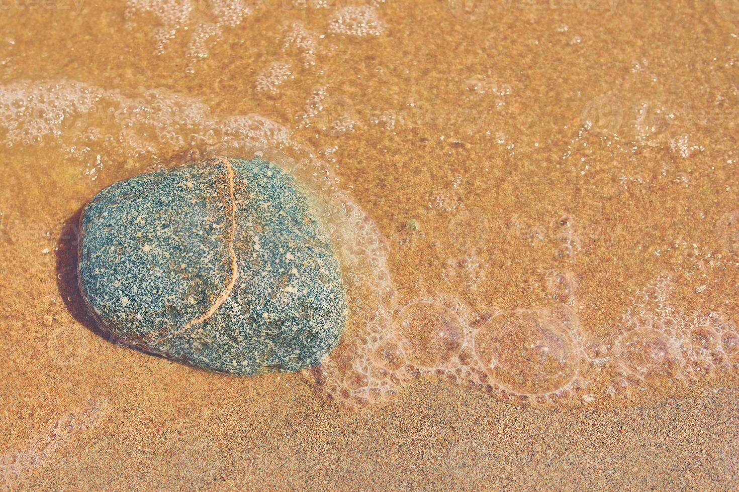 Rocks on the sand. Sand beach background. Top view. photo